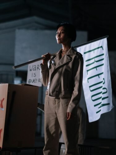 زنی با پرچم «آزادی» در یک تجمع اعتراضی